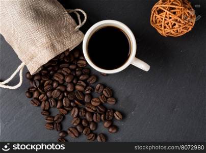 Heap coffe beans and cup of fresh coffee. Heap coffe beans and cup of fresh coffee on dark background