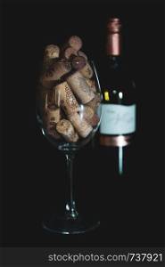 Heap of assorted wine corks in wine glass on black background. wine corks in the wine glass. isolated background