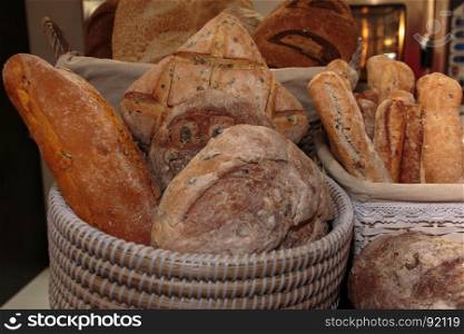 Heap of Bread Rolls Assortment and French Loaf inside Wicker Basket