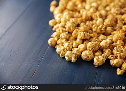 Heap of Caramel Corn Background on blue rustic table. Close up. Copy space for your text.