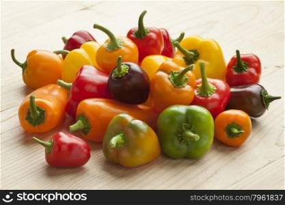Heap of colorful vine sweet mini peppers on white background