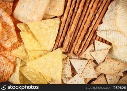 Heap of crunchy potato crisps, breadsticks and cookies, concept of restriction eating unhealthy and salted food. Heap of salted crunchy crisps, breadsticks and cookies, concept of unhealthy food