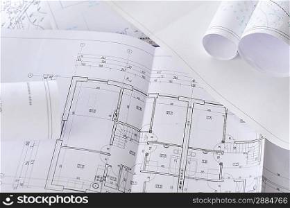 heap of design and project drawings on table background.