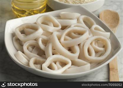Heap of fresh raw squid rings on a dish