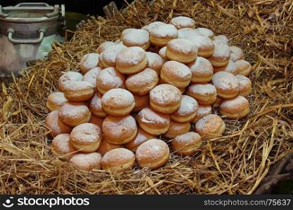 Heap of Fried Bavarian Cream Filled Donuts on Bed of Straw