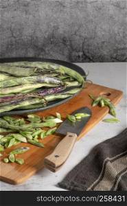 Heap of green beans on a rustic wooden table top view. Cutting board with green beans