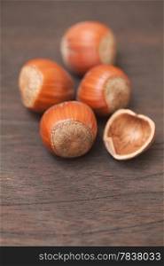 heap of hazelnuts on a wooden surface