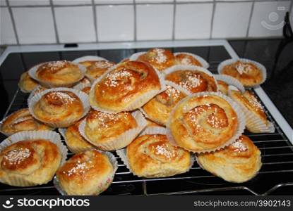 Heap of newly baked delicious cinnamon buns on the stove-top
