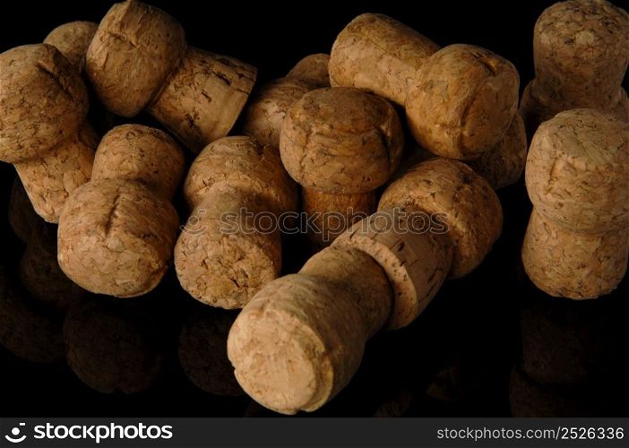 Heap of old wine corks on black background with reflection. Wine corks on black background