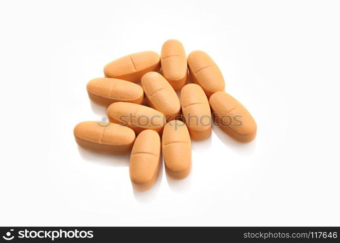 Heap of orange pills isolated on white background