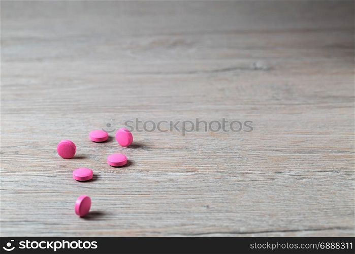 Heap of pink round pills on bright table. Heap of pink round pills on bright background