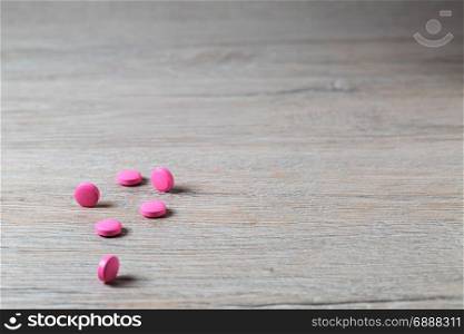 Heap of pink round pills on bright table. Heap of pink round pills on bright background