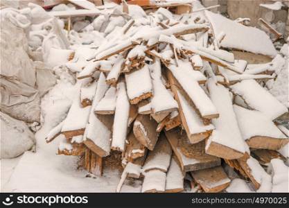 Heap of planks covered with snow