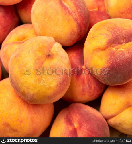 heap of ripe yellow-red round peaches, close up