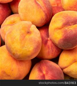 heap of ripe yellow-red round peaches, close up