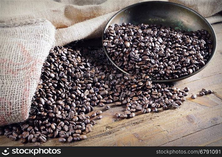 Heap of roasted coffee beans on wooden table