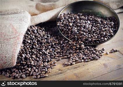 Heap of roasted coffee beans on wooden table