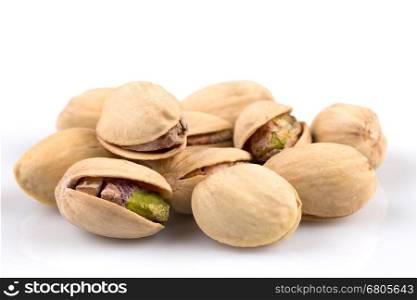 Heap of salted pistachio nuts isolated on white background
