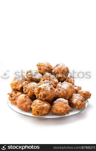Heap of sugared oliebollen or fried fritters on glass dish isolated on white background