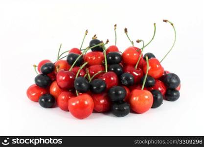 Heap of sweet cherries and blueberries isolated on white