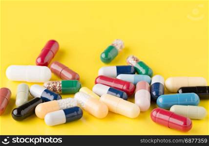Heap of various pills on color background. Heap of various pills on yellow background
