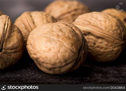 Heap of walnuts on a dark textured background. Heap of walnuts