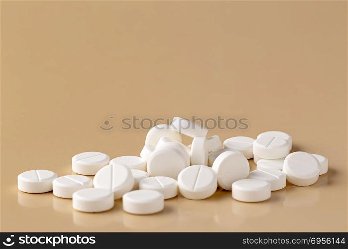 Heap of white round pills. Heap of white round pills on beige background