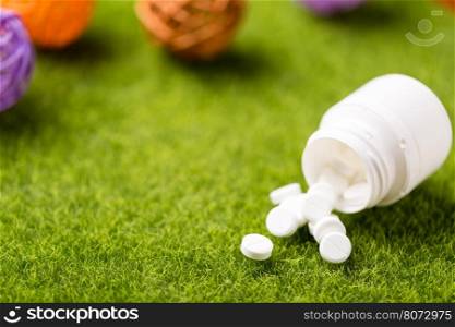 Heap of white round pills. Heap of white round pills on green grass background