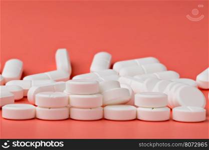 Heap of white round pills. Heap of white round pills on pink background