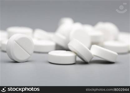 Heap of white round pills medical. Heap of white round pills medical on a gray background