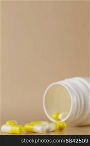 Heap of yellow pills. Heap of yellow capsules closeup on beige background
