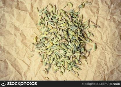 Heap pile of dried fennel dill seeds on paper surface. Heap of fennel dill seeds on paper surface