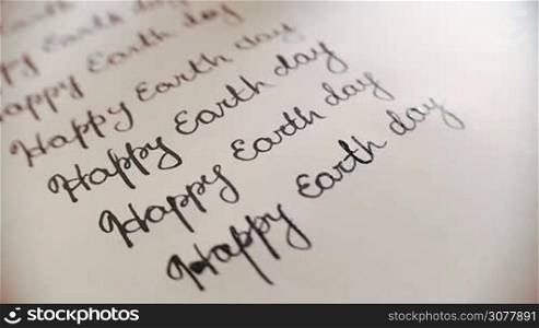 Heappy earth day calligraphy and lattering typographical design. Ninth line. Close-up whith audio