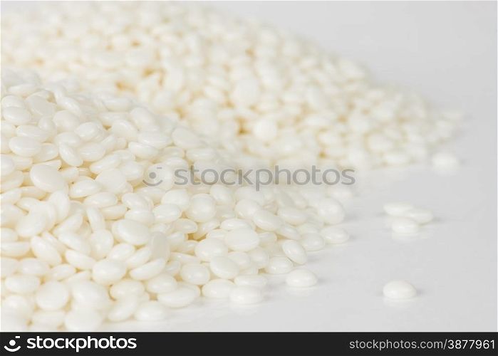 Heaps of fine white polymer granules isolated on white background