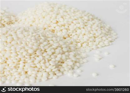 Heaps of fine white polymer granules isolated on white background