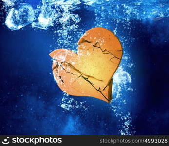 Heart dissolve under water. Broken heart sinking and dissolving in clear blue water