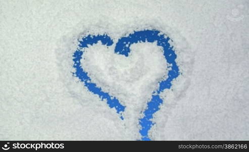 Heart drawn on snow background with matte