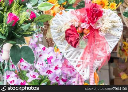 heart flowers decoration with red roses and white sheaf of wheat - colorful flowers in background