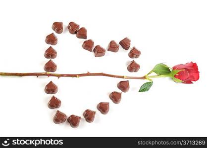 Heart from chocolate candies and Cupid&acute;s Arrow from rose