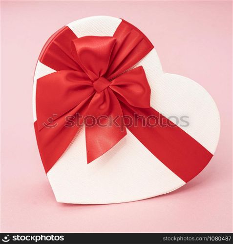 Heart Gift box with ribbon on pink surface