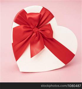 Heart Gift box with ribbon on pink surface