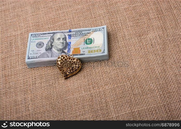 heart icon bundle of US dollar placed on a linen canvas