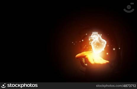 Heart in hand. Close up of businessman holding digital glowing heart in palm