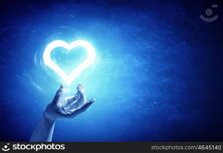 Heart in hand. Person holding digital glowing heart in palm
