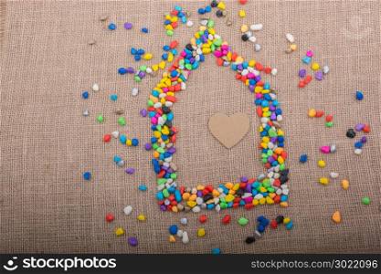 Heart in the house form shaped by colorful pebbles