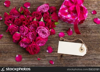 heart of fresh roses buds with gift box and emty tag isolated on white background
