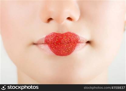 heart on stawberry lips of pretty woman closeup