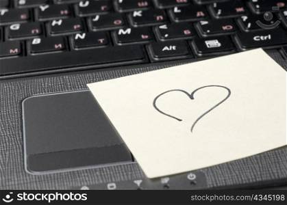 heart on sticky note on computer keyboard