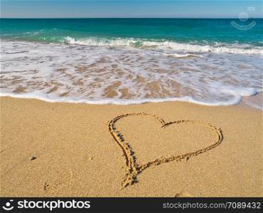 Heart on the sand of a beach. Romantic composition.