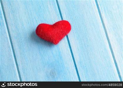 Heart on wooden table. Red heart on blue wooden table